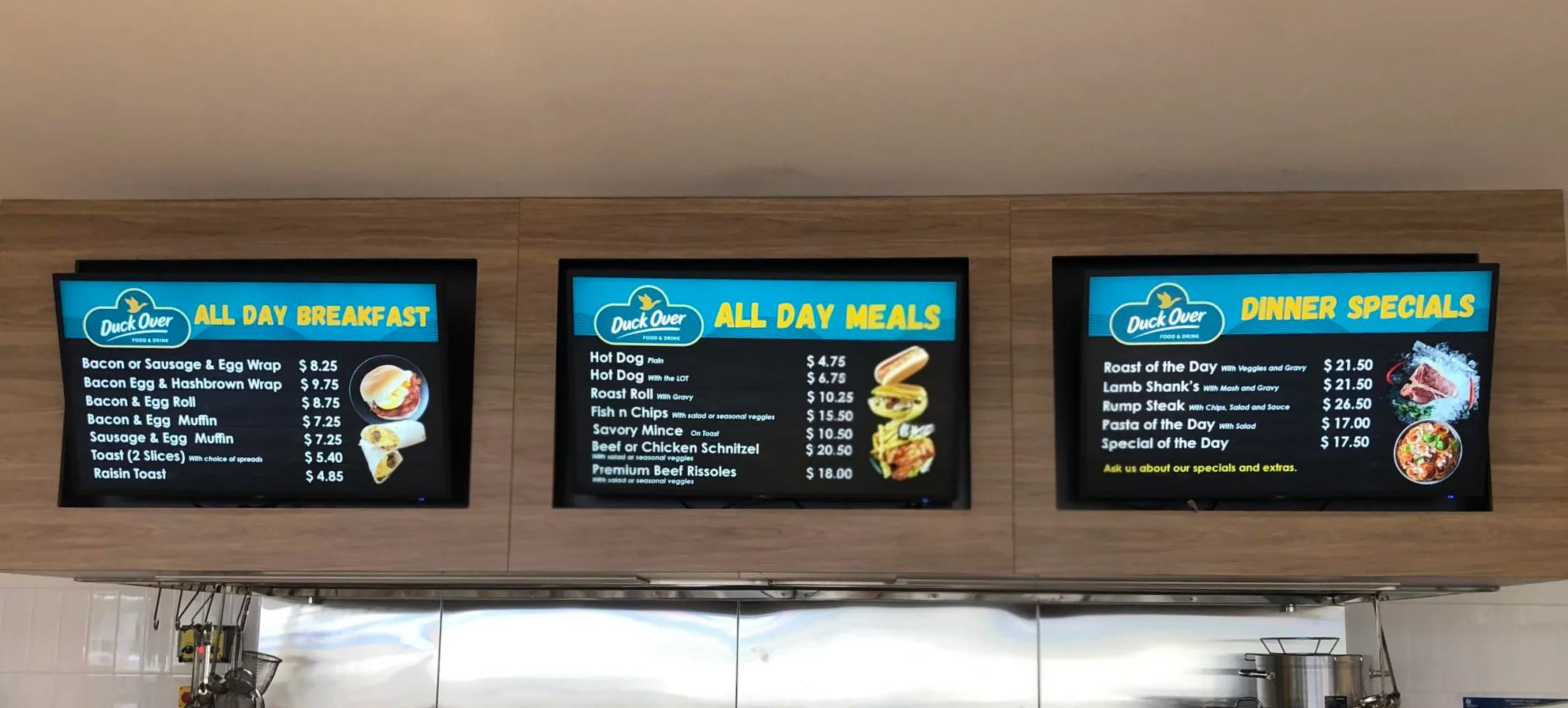 LCD digital menu boards displaying breakfast, meal, and dinner specials at Duck Over Food & Drink